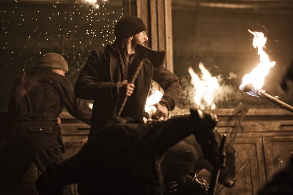 Torches illuminate the fight scene through a train car.
