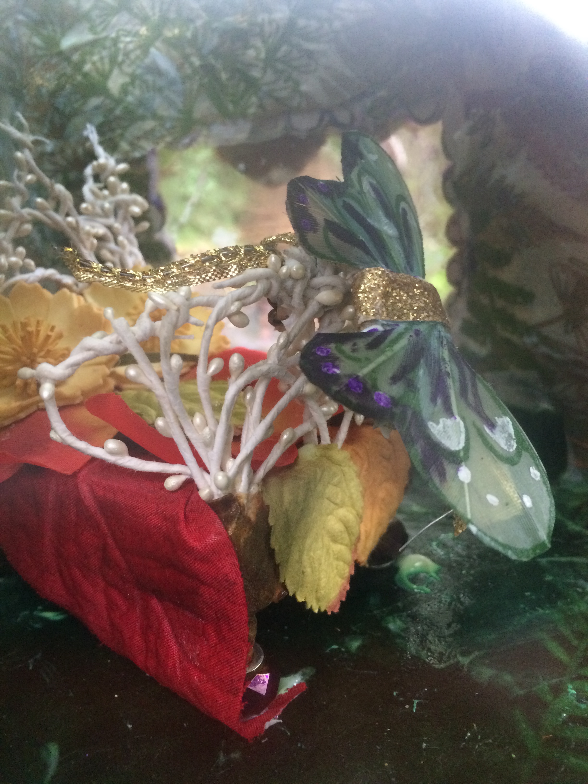 Looking through the mica windows, you can see Thumbelina's wings hung on her bedpost. Thumbelina isn't a fairy. When she married the fairy prince, the fairies gave her a pair of wings and changed her name to "May Queen Of The Flowers." 