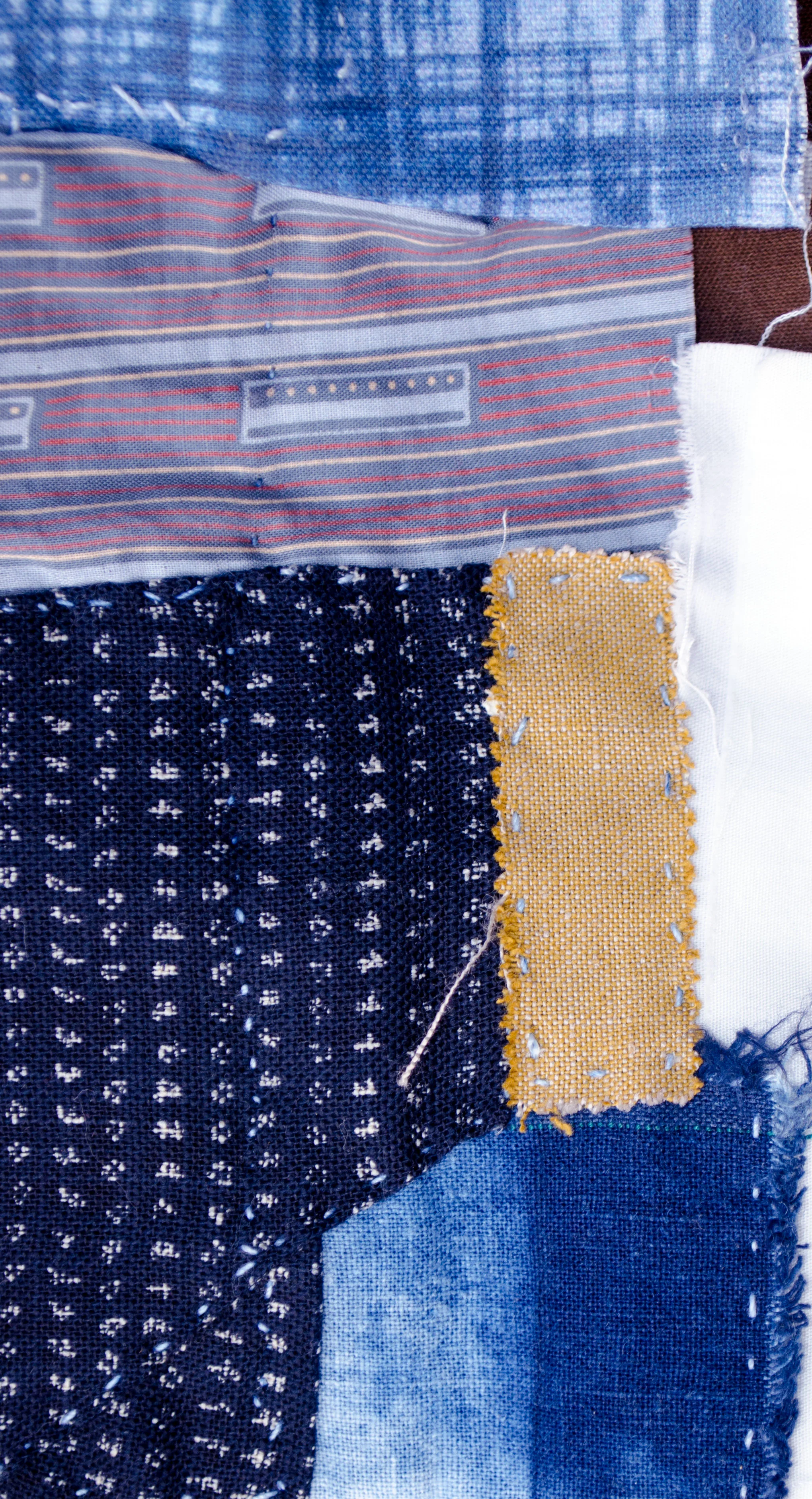 Bits of linen and cotton, shibori dyed and block printed stitched to patch an old jacket in the boro style
