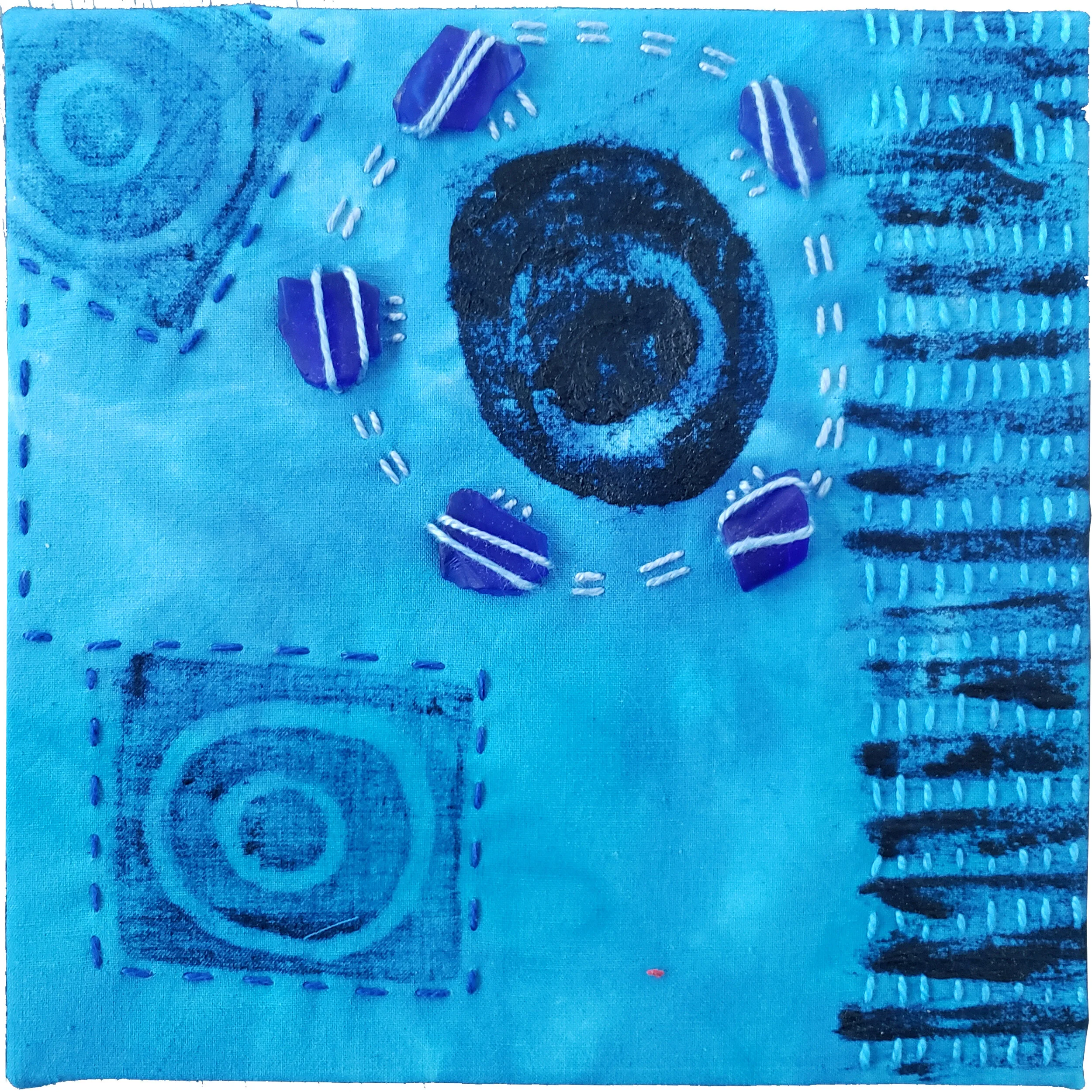  Held in Common: Blue #7  6” x 6” x 3/4” Indigo-dyed fabric, hand-stitched with scavenged sea glass, block printing, and industrial waste offcuts, laminated onto a Baltic birch plywood panel