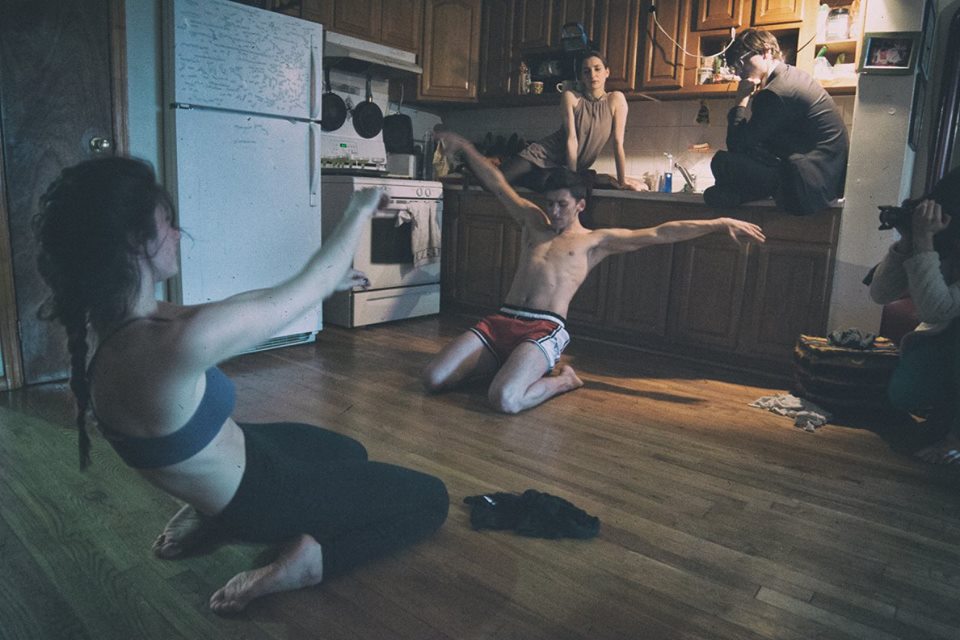Lia Bentley and Adam Robert Dickerson dance in a kitchen. Dancer Vera Paganin and composer Wes Braver watch from "onstage;" Keenan Parry films. Credit Joe Desimone. 