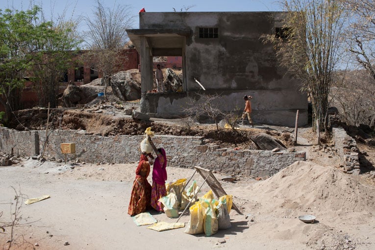Les femmes portent les sacs de ciment sur leur tête
