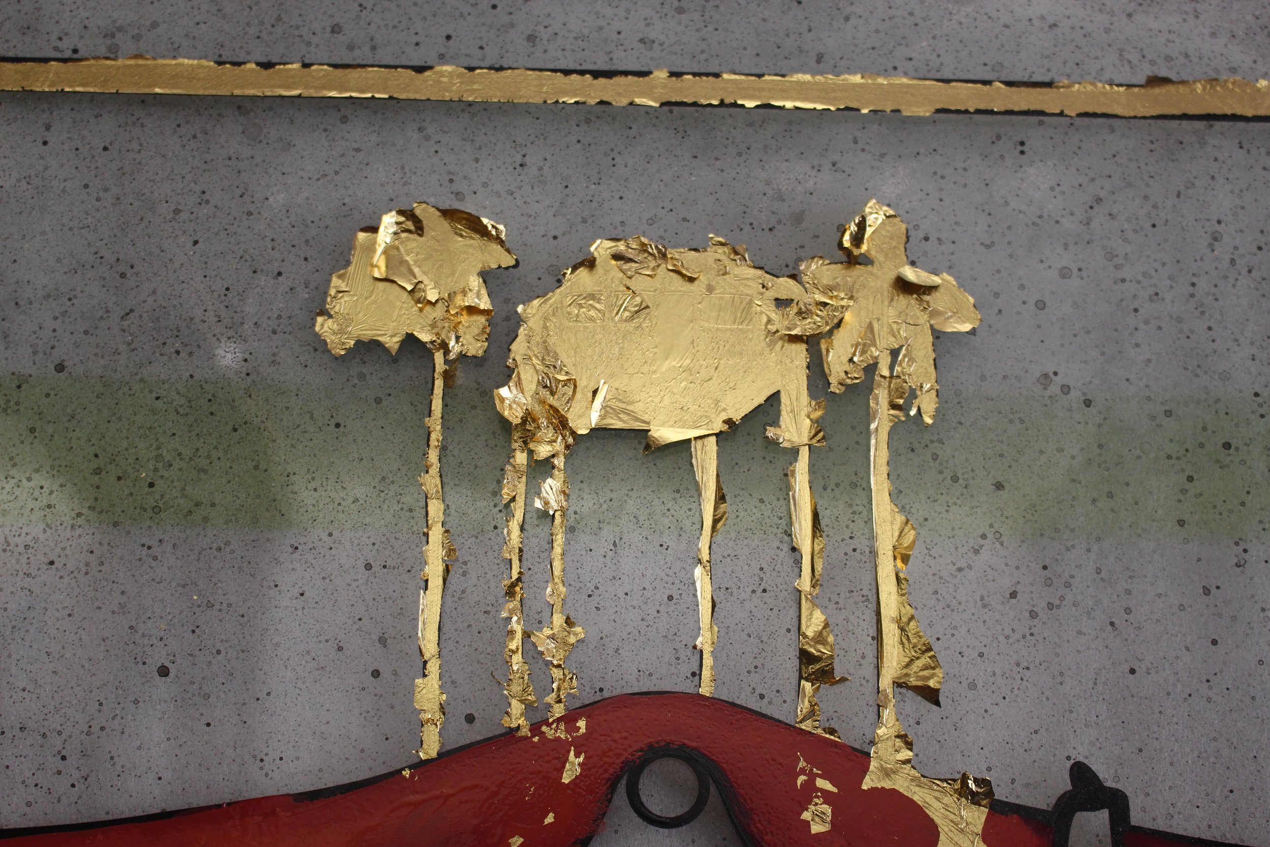  Gold leaf applied with an oil size on the reverse side of the glass.  Excess gold is removed once the gold size is dry 
