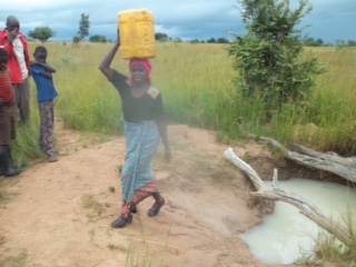  Preparing to walk the long distance home from the local water hole. Njebe, Zambia. 