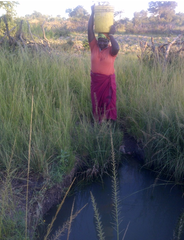 Preparing to walk water back to the family. Siachihja, Zambia. 