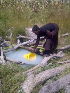 Gathering water from the "clean" water source in Mayoba, Zambia. 