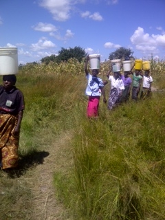  Women walking the distance to collect their daily water in the village of Mayoba. 