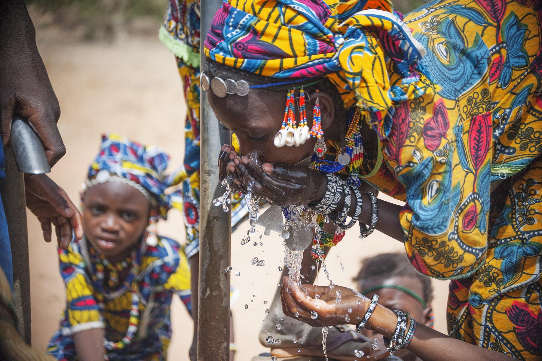 This beautiful image shows a woman in Niger enjoying fresh water from the local well. Photo by Jerry Atnip.