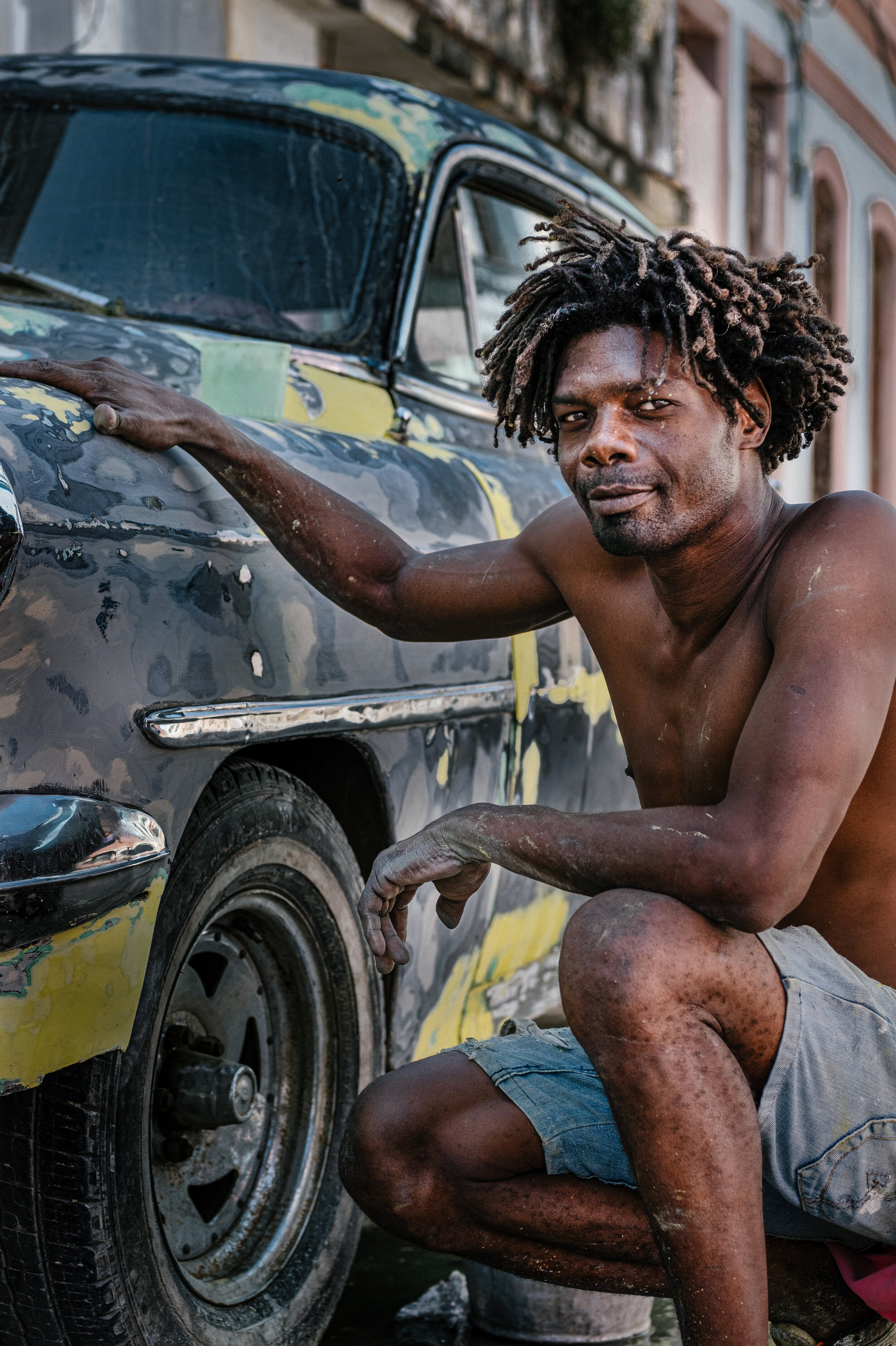 A Cuban man painting a car in Cayo Hueso – Havana, 2018