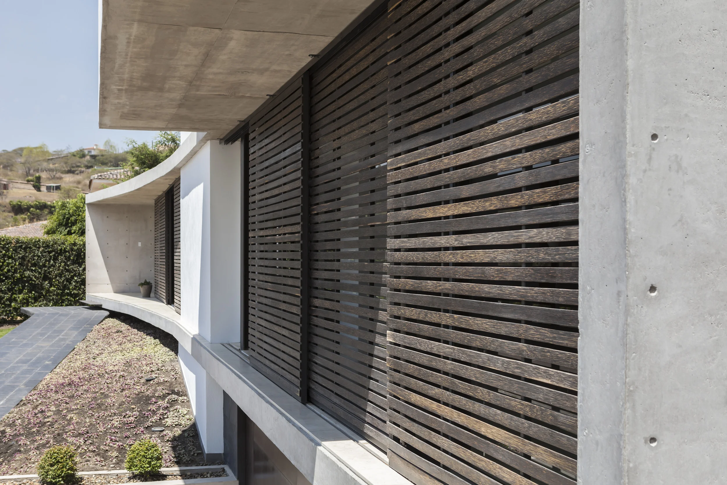 Casa L6, celosías de madera en fachada frontal para controlar la entrada de luz y privacidad de la casa. Diseñada por Endara Arquitectos.