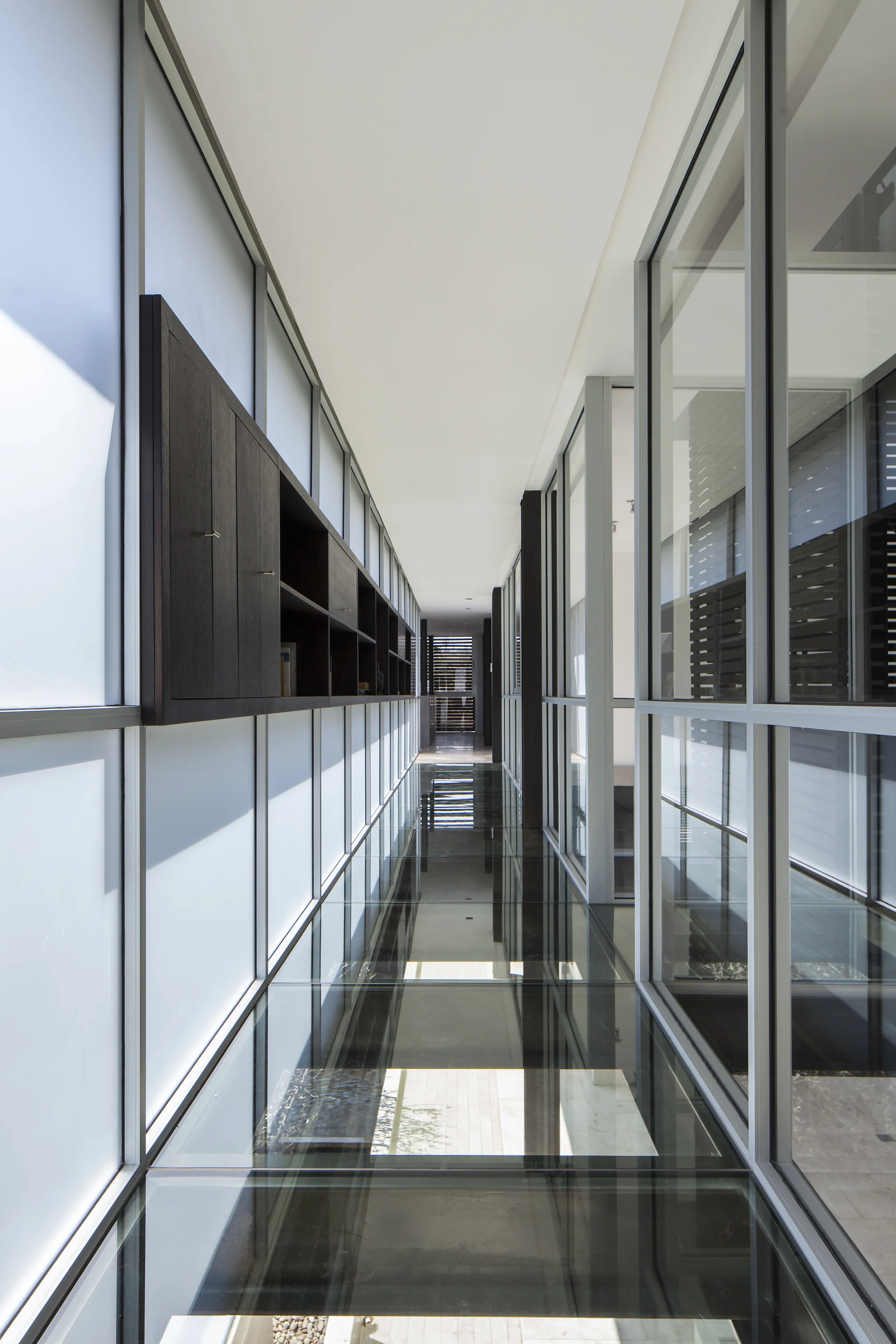 Casa L6, Pasillo superior de vidrio en sus lados y piso. Diseñado por Endara Arquitectos.