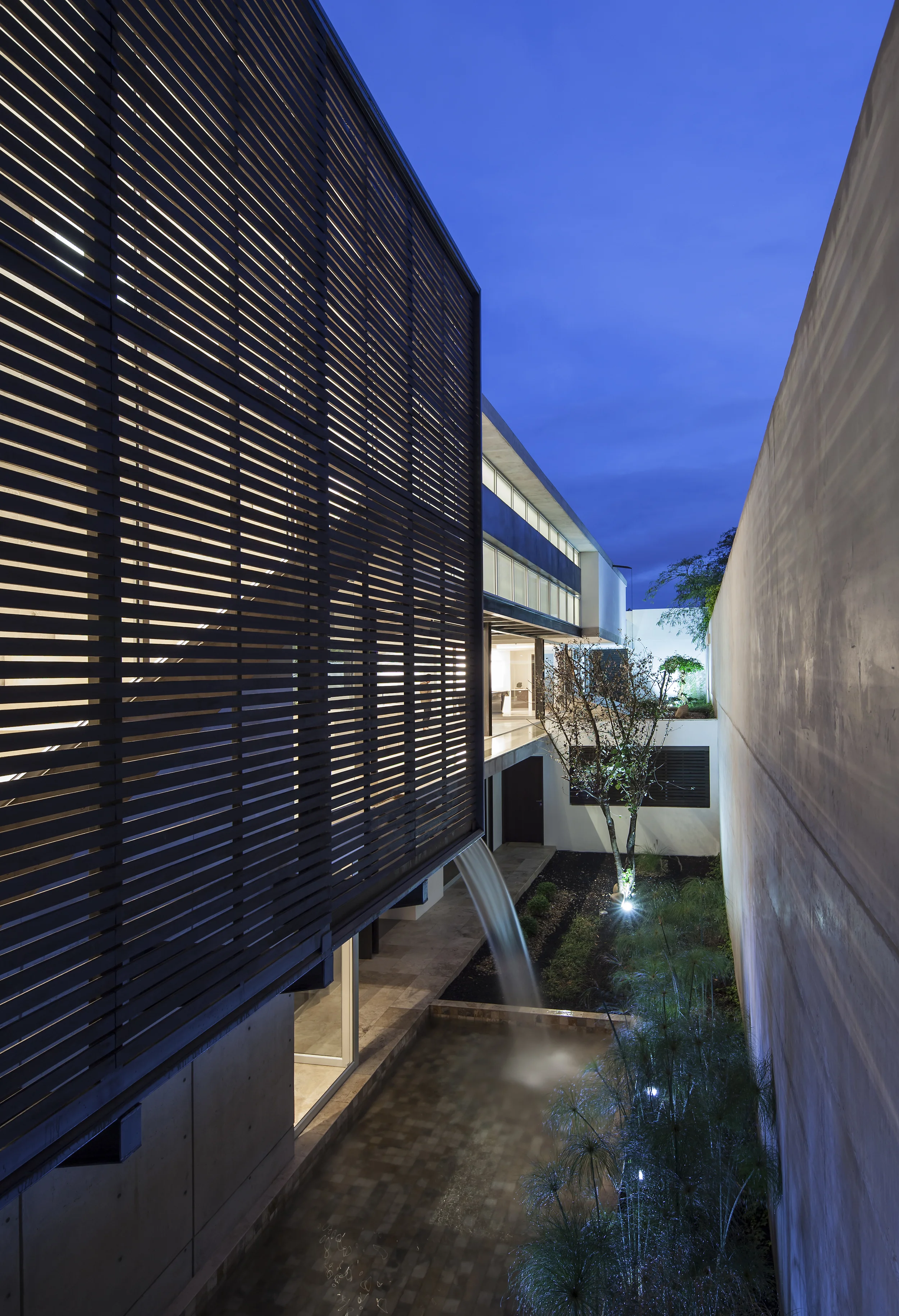 Casa L6, patio exterior en el nivel -1, con un espejo de agua y pileta. Diseñado por Endara Arquitectos