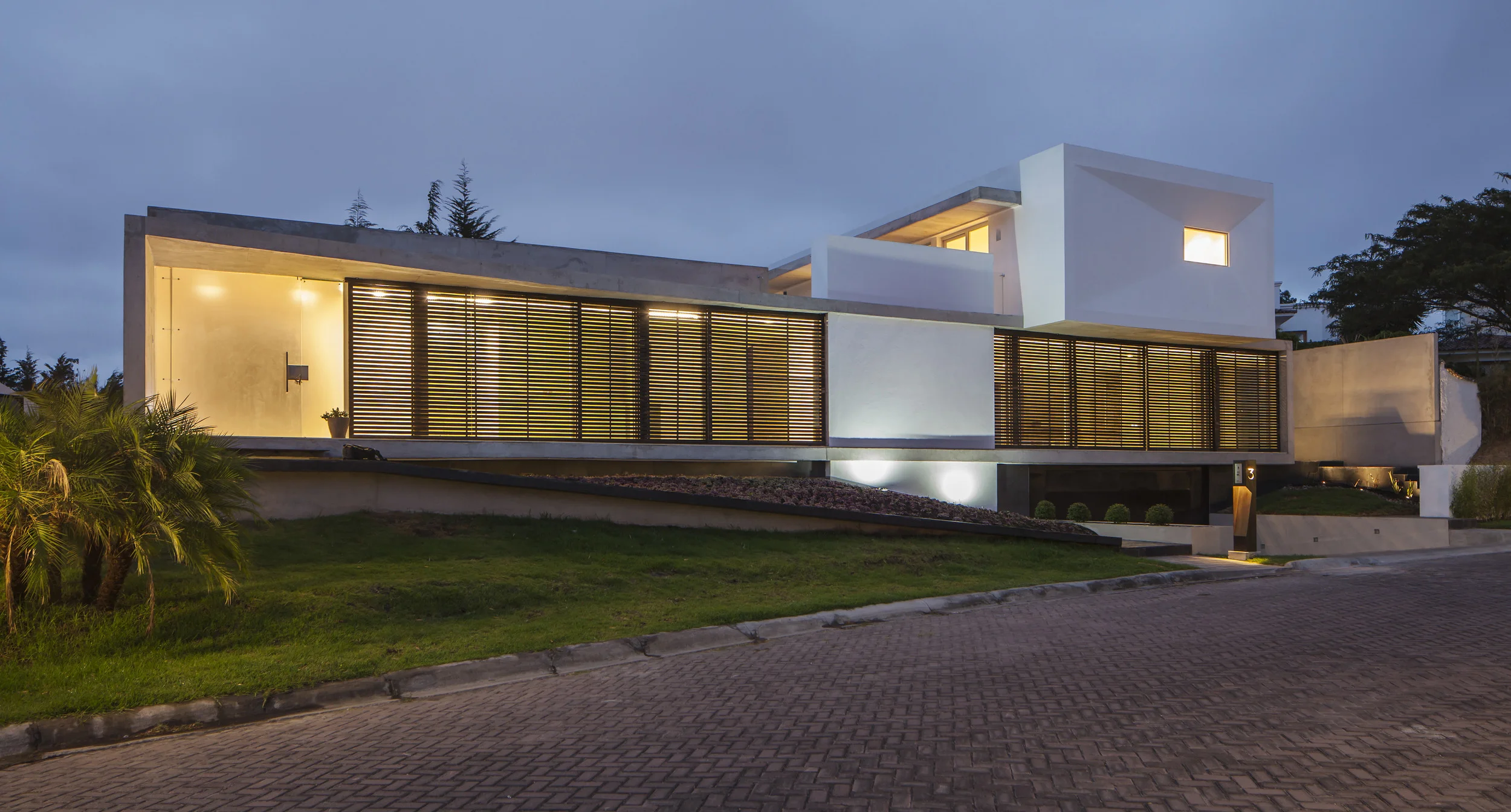 Casa L6, fachada frontal moderna, de hormigón, madera y vidrio. Diseñada por Endara Arquitectos