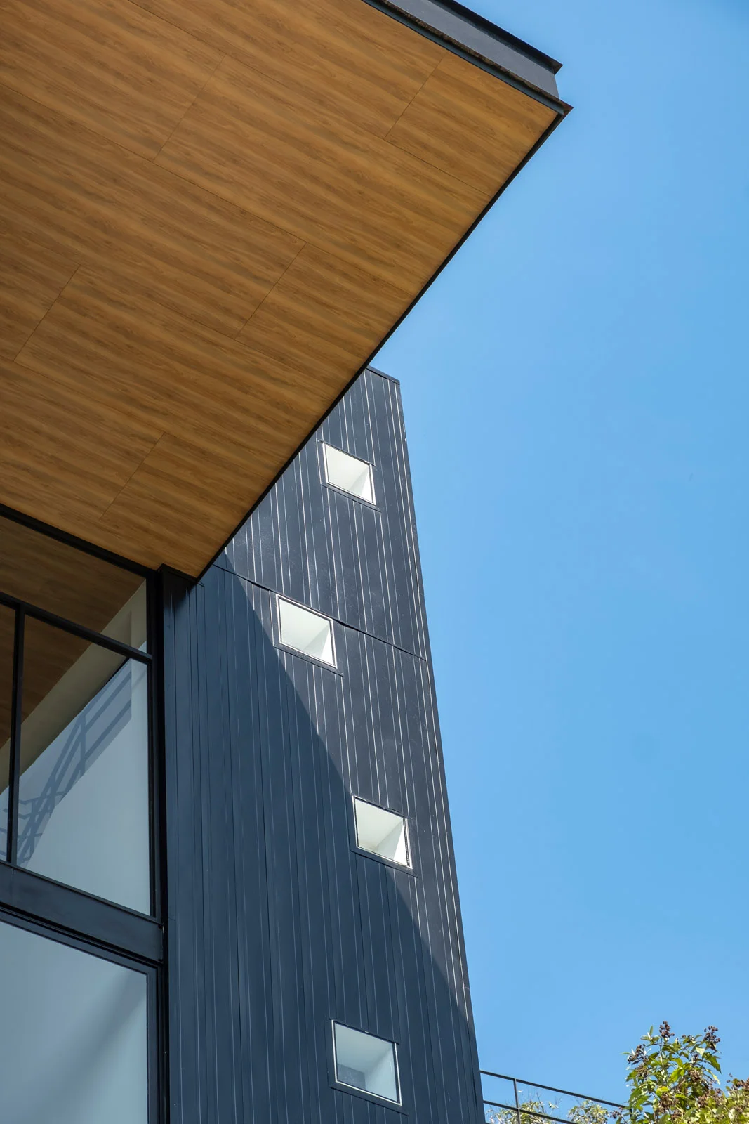 Detalle de fachada de una de las tres viviendas independientes de Pillagua Barranco, con revestimiento de acero y cubierta de madera. Proyecto diseñado por ENDARA ARQUITECTOS en Cumbayá.