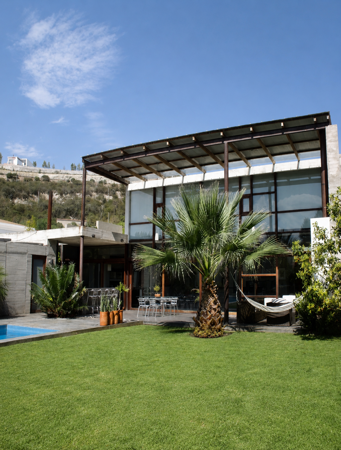Casa Pillagua, fachada posterior, porche doble altura, columnas redondas metálicas. Diseñado por Endara Arquitectos.