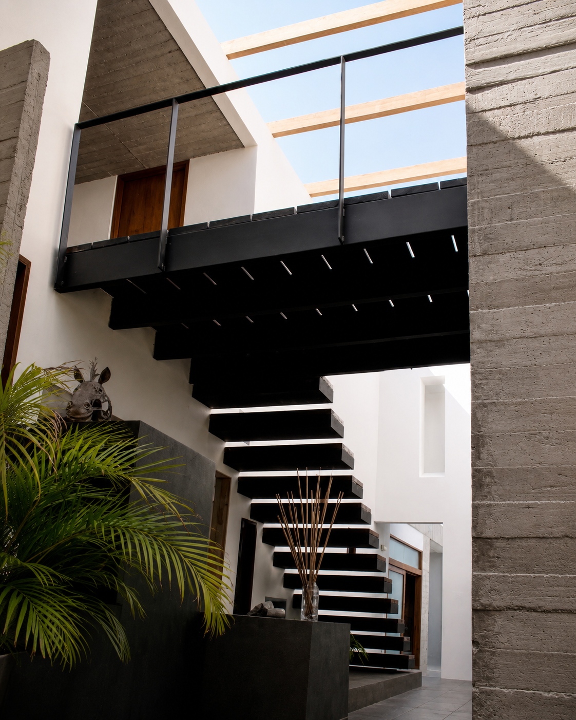 Casa Pillagua, vista inferior de las gradas, viendo el techo de vidrio en una doble altura. Diseñado por Endara Arquitectos.