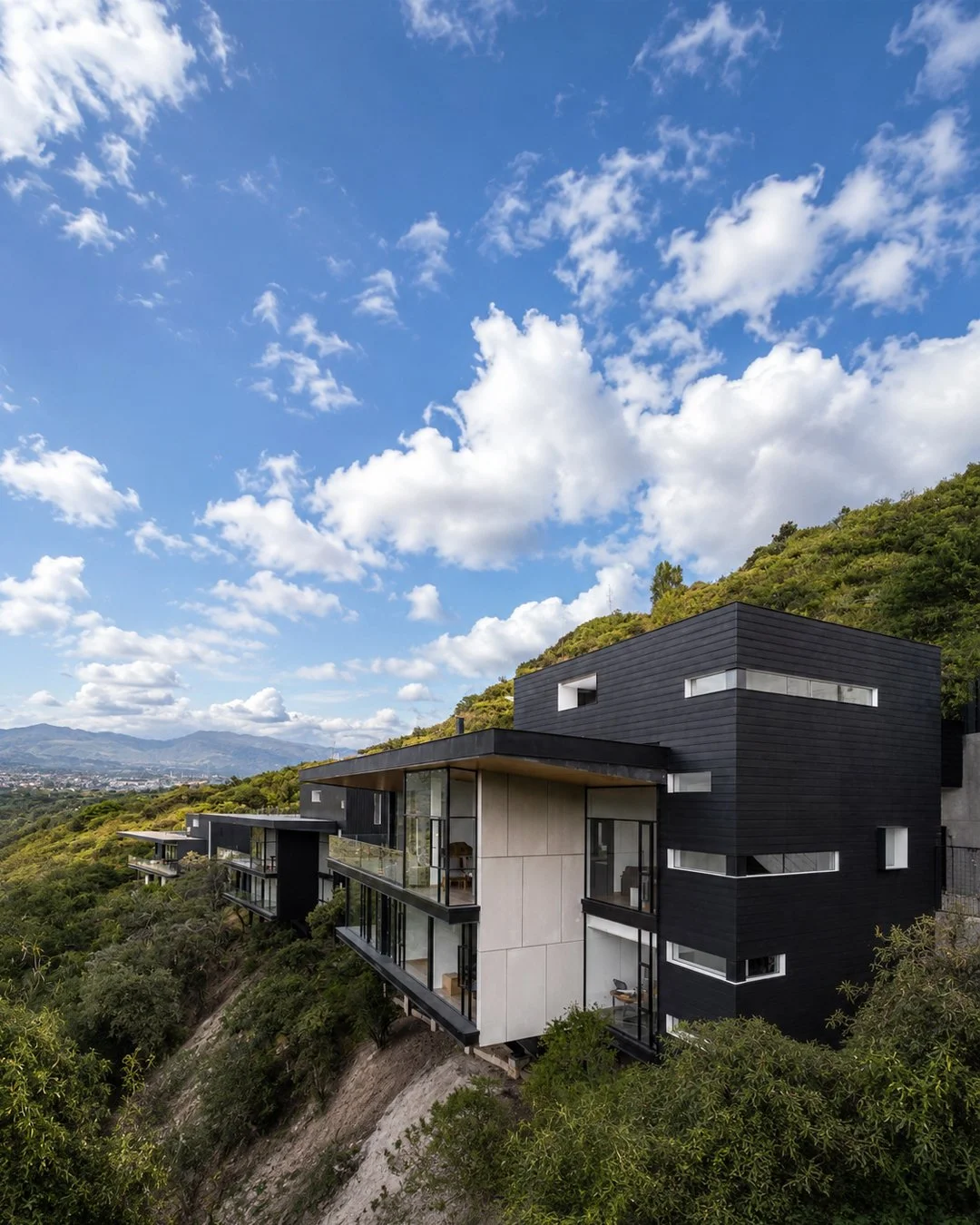 Vista exterior de las tres viviendas independientes de Pillagua Barranco, implantadas en la ladera de Cumbayá y diseñadas por ENDARA ARQUITECTOS.