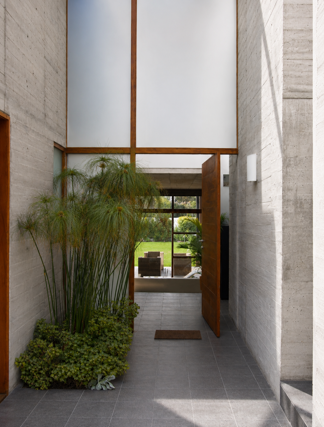 Casa Pillagua, puesta de acceso principal, puerta de madera, y paredes de hormigón visto. Diseñado por Endara Arquitectos.