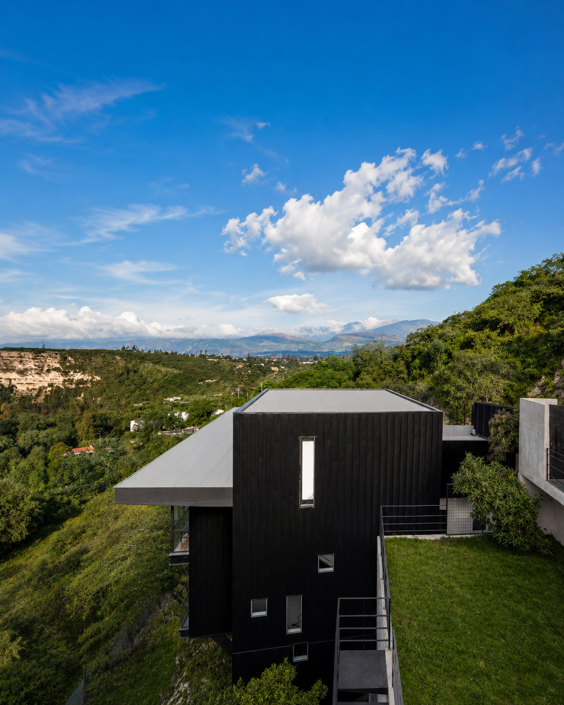 Vista de la fachada lateral de una de las tres viviendas independientes de Pillagua Barranco y el jardín de otra de las vivienda, integradas en la ladera de Cumbayá. Proyecto diseñado por ENDARA ARQUITECTOS.