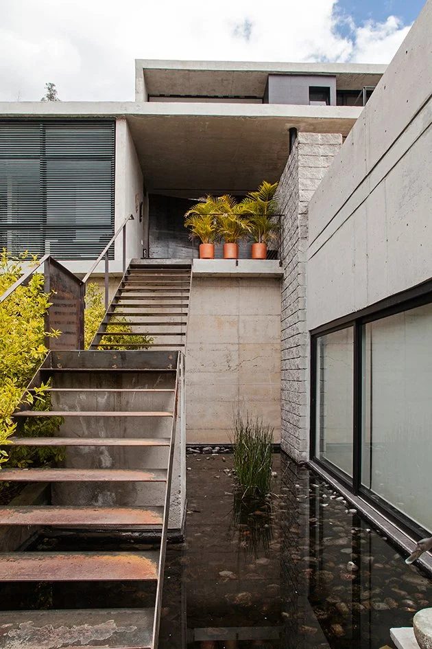 Casa Estudio Endara, entrada principal, gradas de metal encima de un estanque de peces koi. Diseñado por Endara Arquitectos.