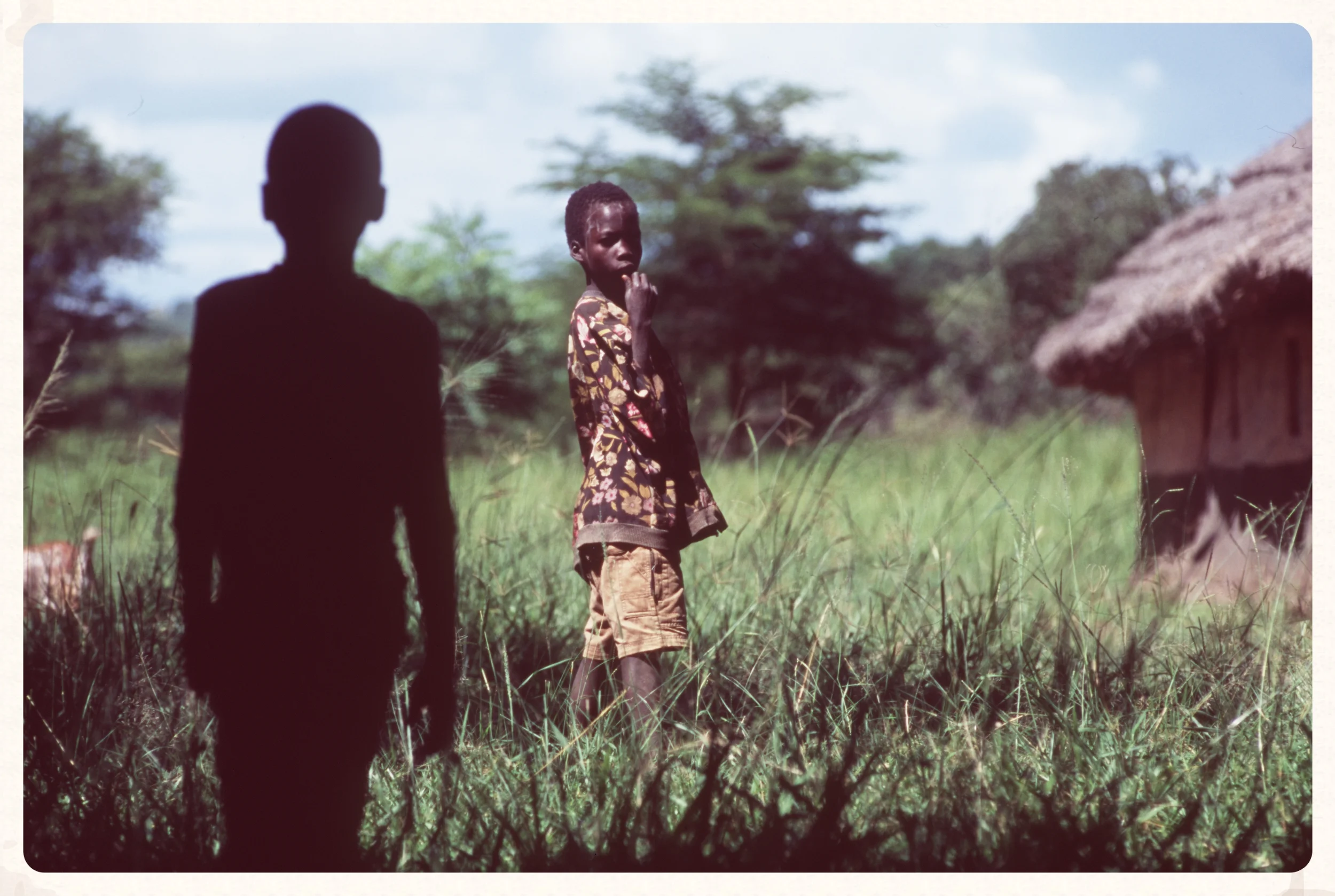  Boys stand next to their huts in South Sudan. 