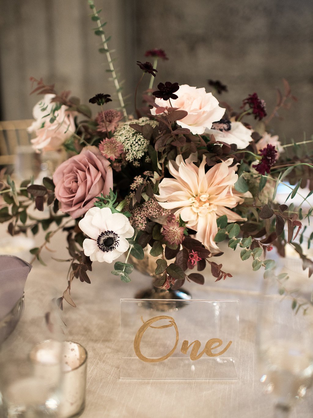 Romantic reception table centerpiece with lush florals and candles at The Mountain Winery wedding reception.