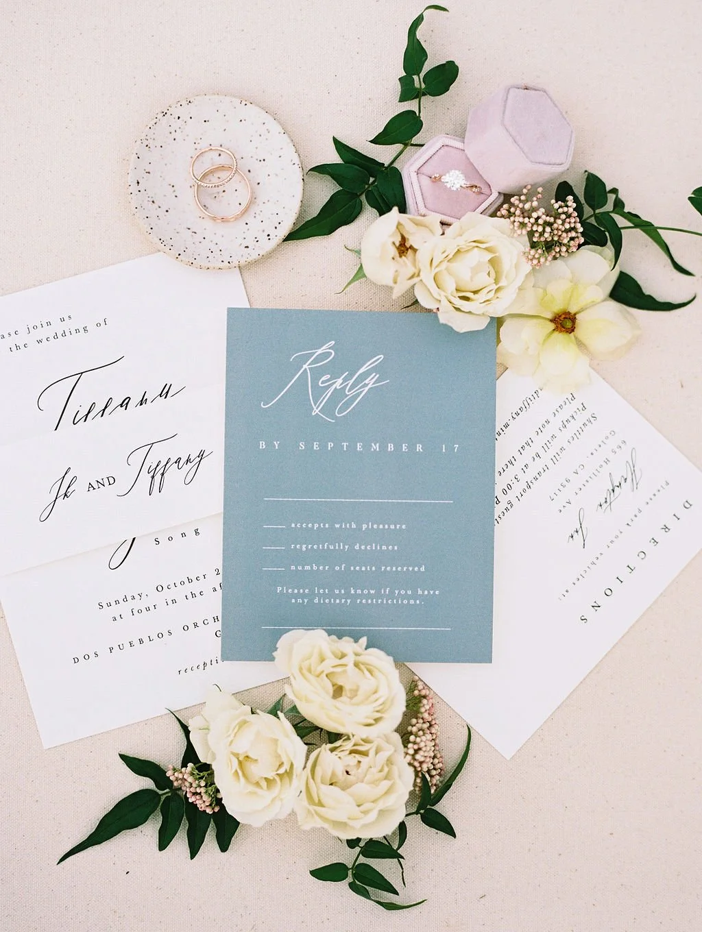 Wedding invitation suite and stationery flatlay styled with florals at Dos Pueblos Orchid Farm in Santa Barbara.