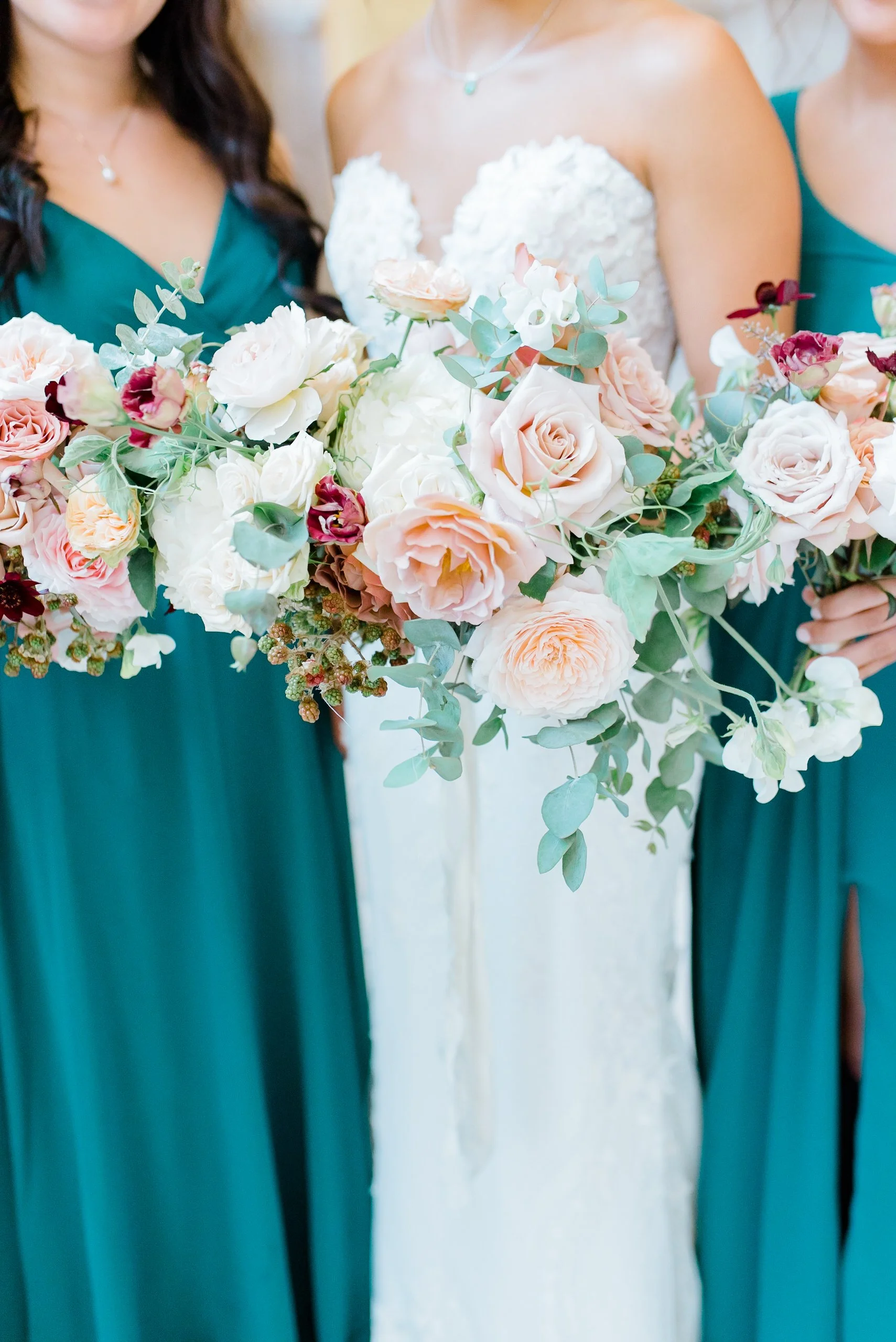 Bridal bouquet with soft blush and ivory florals held among bridesmaids in teal dresses at a San Francisco City Hall wedding.