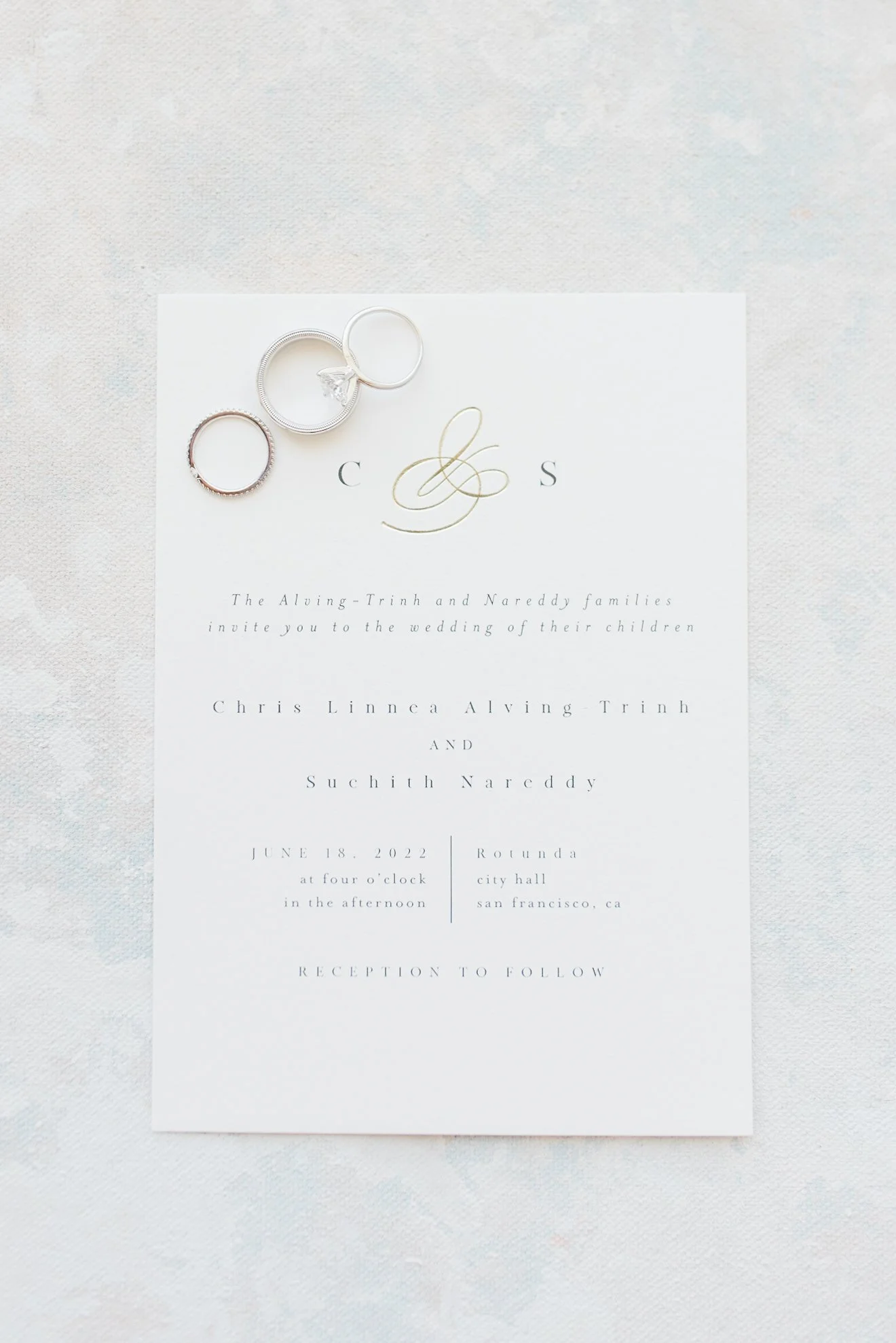 Flatlay of minimalist wedding invitation suite and rings for an elegant San Francisco City Hall wedding.