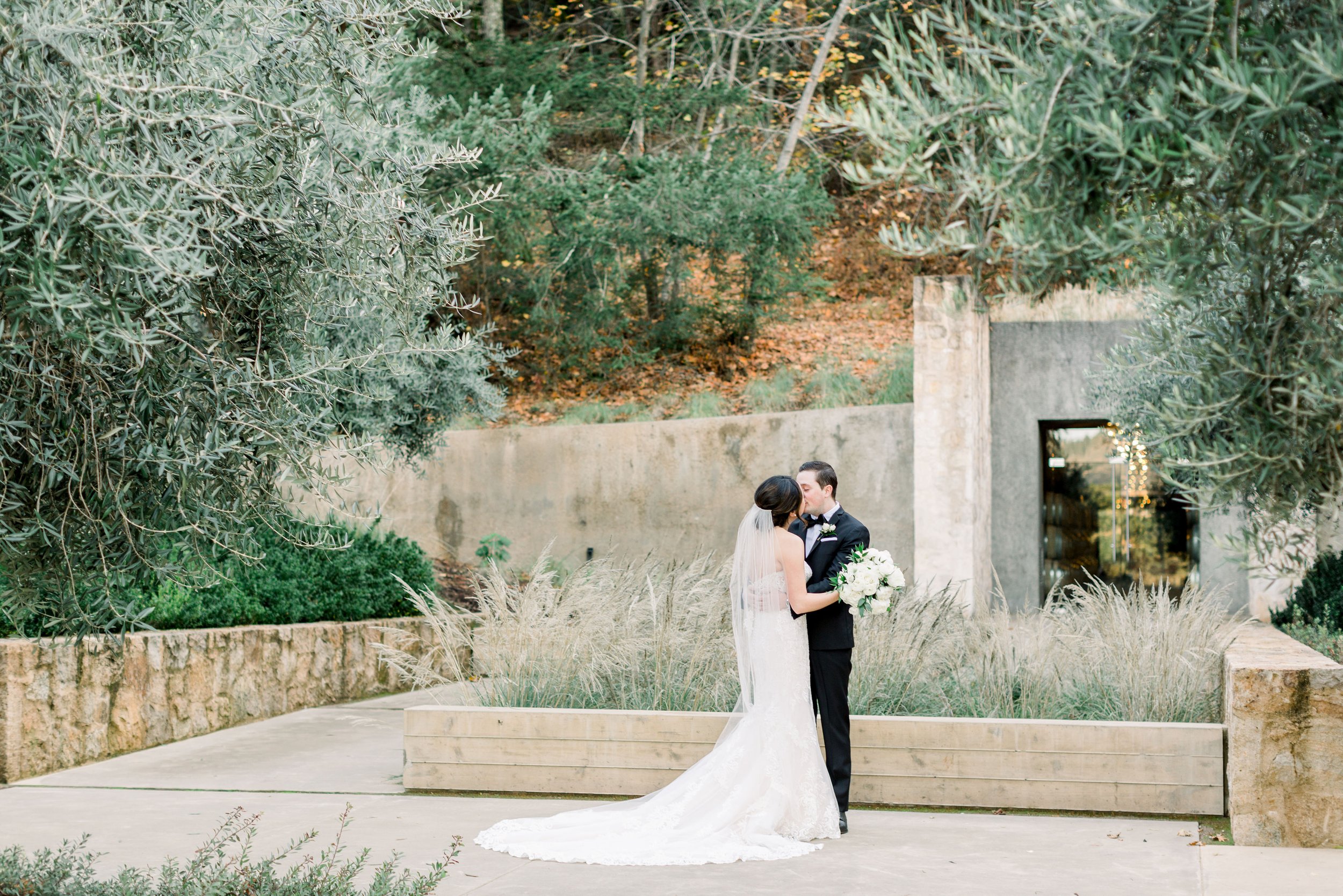 Bride and groom sharing a romantic moment in the olive tree courtyard at Brasswood Estate in Napa Valley.