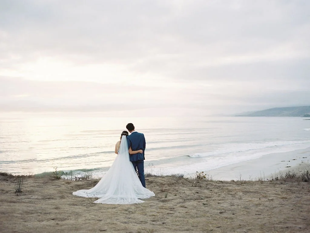 Bride and groom overlooking the Pacific Ocean during a Dos Pueblos Orchid Farm wedding in Santa Barbara.