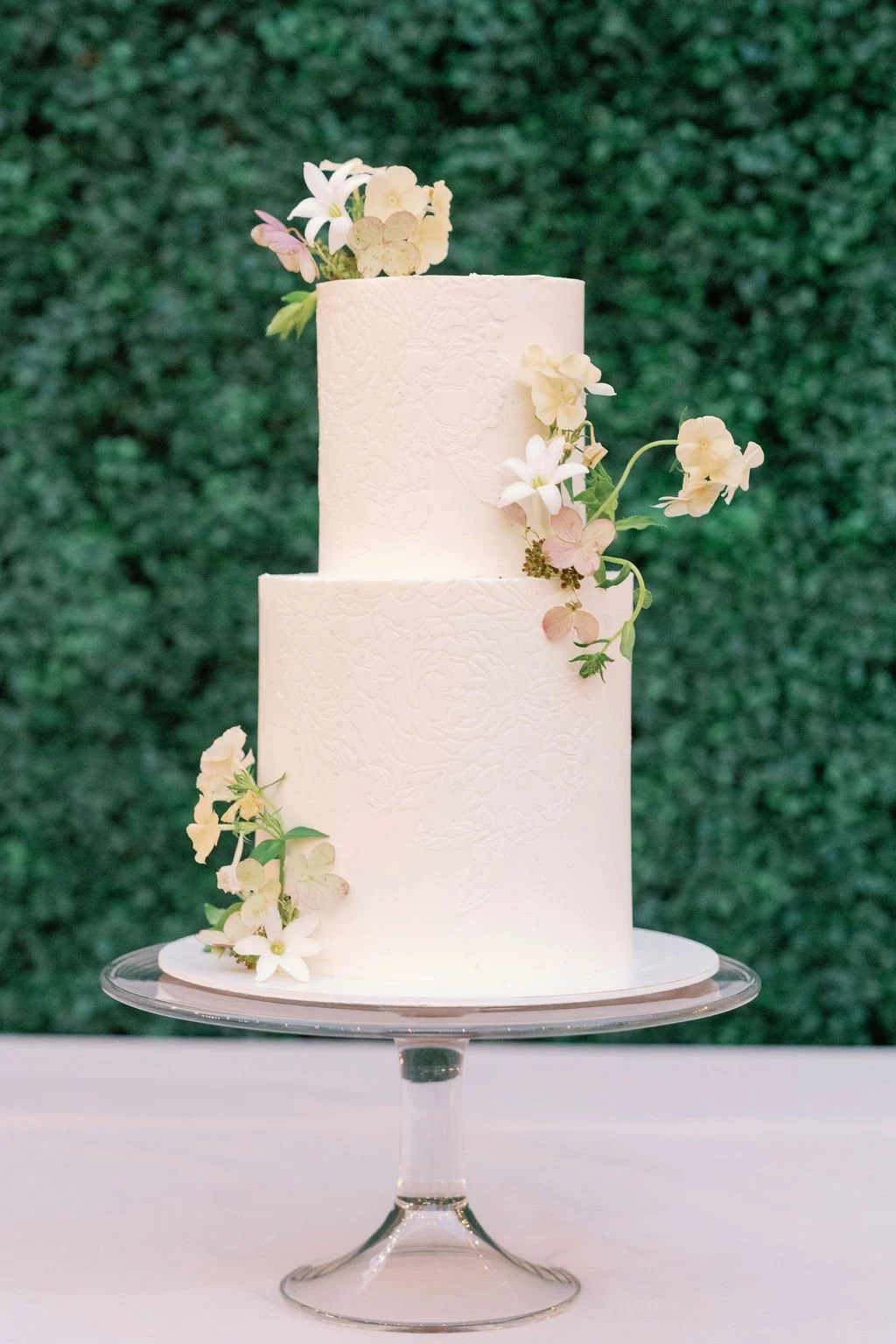 Minimal white wedding cake with floral details at Mountain Terrace garden reception