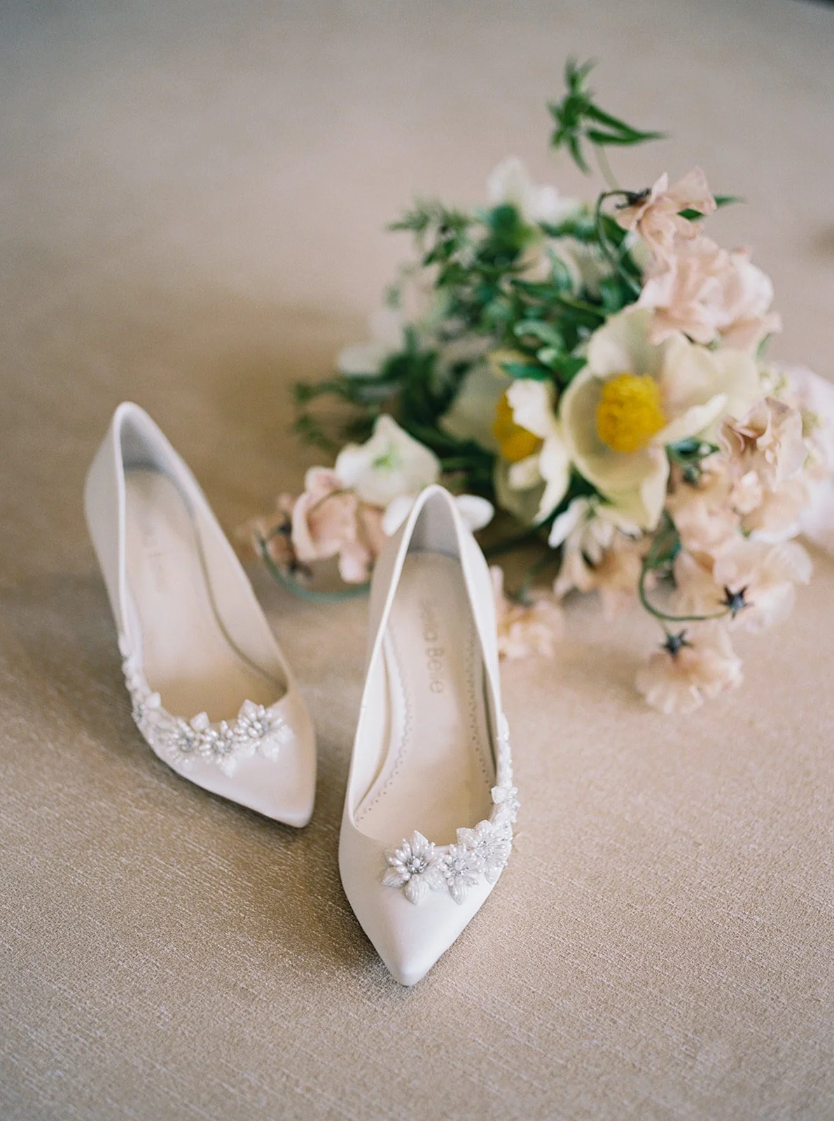 Elegant bridal heels with floral embellishments styled beside a soft garden-inspired bouquet at a Solage Napa Valley wedding.