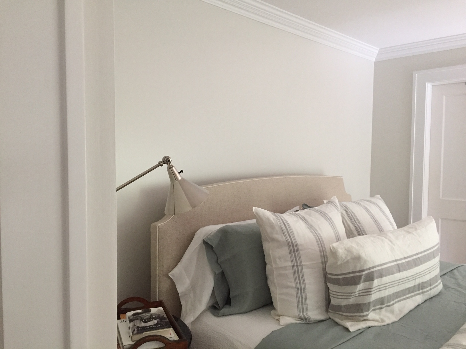 My first guest bedroom, the larger of the two, called out for elegance. This bedroom faces the front yard and is where couples will stay when visiting, or my adult sons, and I was keen to make the experience of being in the room one of serenity and peace. So after much experimentation with all manner of whites, off whites, and greys, I landed on the stunningly subtle shade of Strong White. Traditional, perhaps, but not really. Taking a moment to actually look at the room, now painted several coats, its walls have a depth of color that belies the word white, or the word traditional. A soft, preternatural spirit, both elegant and simple, peaceful and painterly. I centered a large bed at its southern wall and dressed it with Libeco linens that look both cozy and comfortable, and stand out in their muted grey-greens as complimentary accents to Strong White’s elegant canvas. The effect is calming and exquisite.