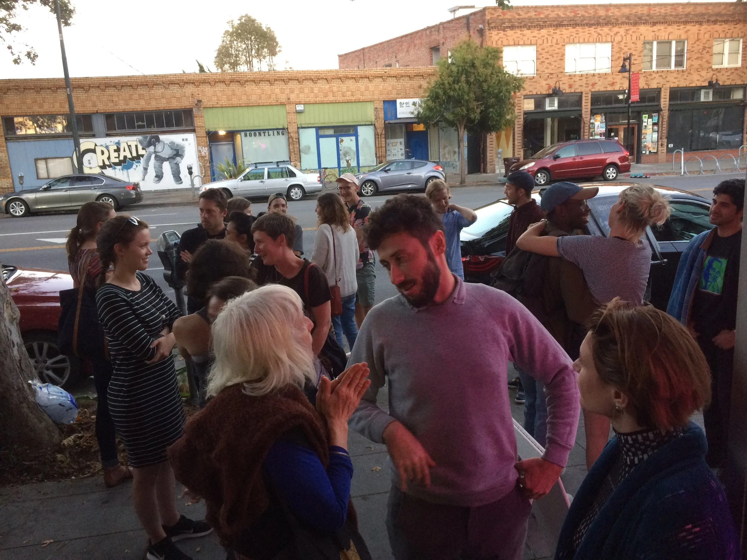 Guests mingle outside Royal Nonesuch Gallery while artists Woody Othello and Ivy Haldeman prepare their presentations. -July 2017