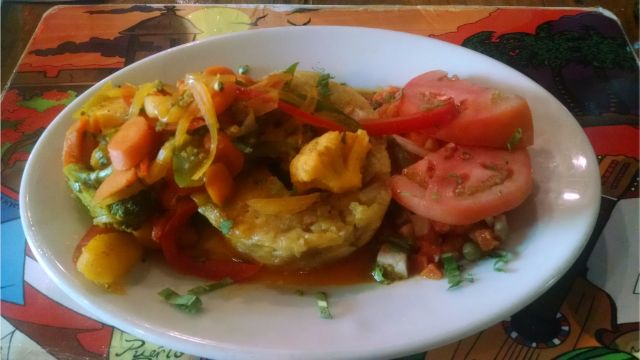 Un plato de magongo con vegetales y ensalada.