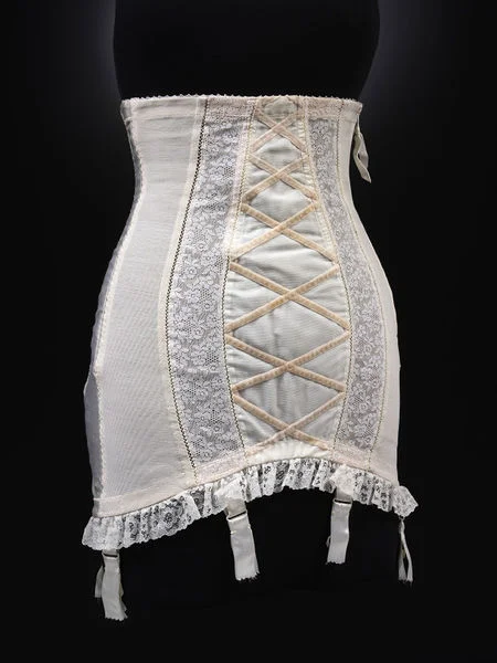 COLETTE GIRDLE - Elastic net and nylon, Satin elastic back panel, with Machine nylon lace and Cotton velvet / 1957-9 Britain (Leicestershire), R. & W.H. Symington & Co. Ltd , under license from Chistian Dior, Paris (V&A:T. 140-2000) * Size - Underbust: 71cm / Waist: 67cm / Hip: 91cm / Length front: 46cm / Back: 50cm Given by Caroline Wren