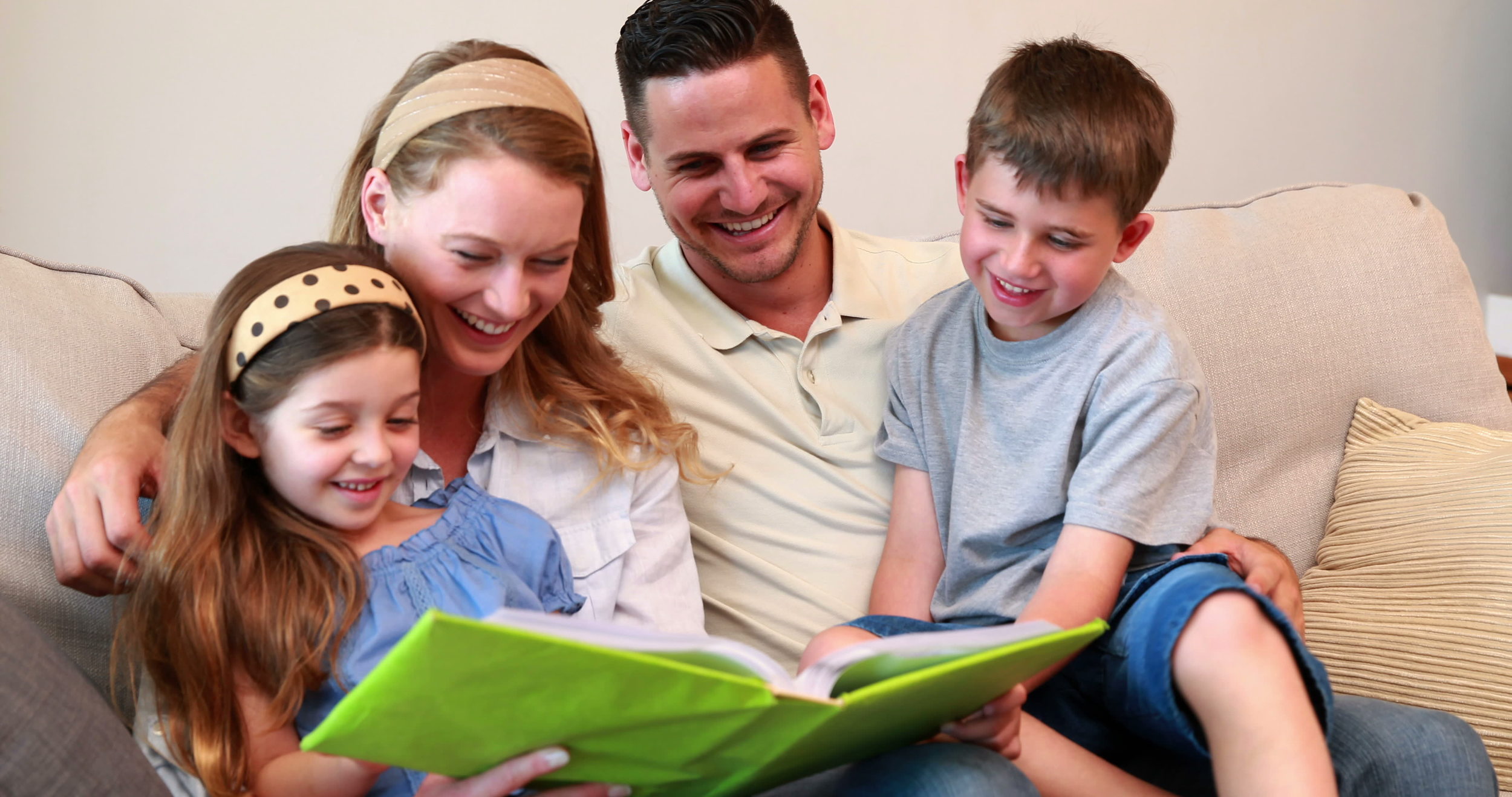 stock-footage-happy-young-family-sitting-on-sofa-looking-at-photo-album-at-home-in-the-living-room.jpg