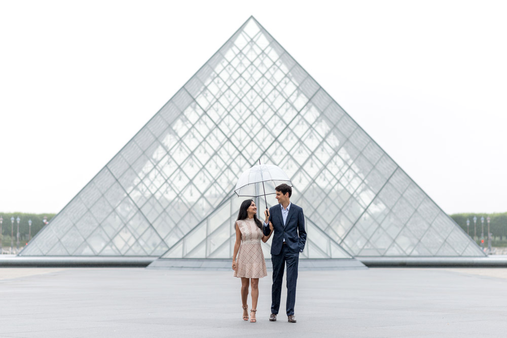 Paris-photographer-Paris-for-Two-Christian-Perona-professional-engagement-proposal-pre-wedding-portrait-Louvre-Museum-sunrise-rain-rainy-day-umbrella-side-by-side.jpg
