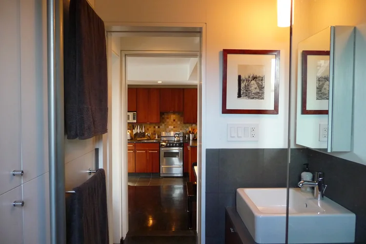  The wall on the left is a series of hidden storage cabinets for toiletries, towels as well as a broom closet. The doors are made of corian. 
