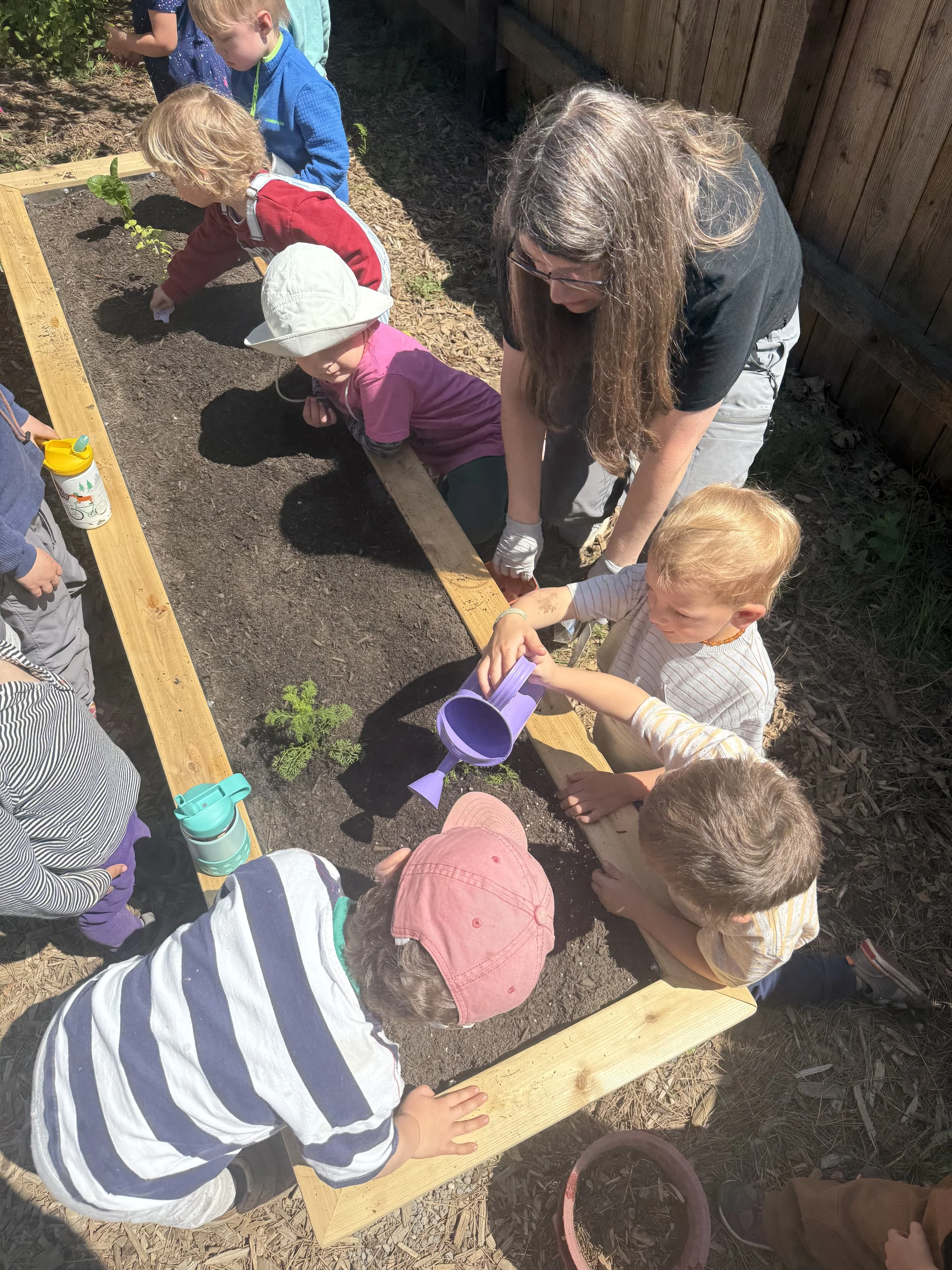 Teacher Susie planting with the children.