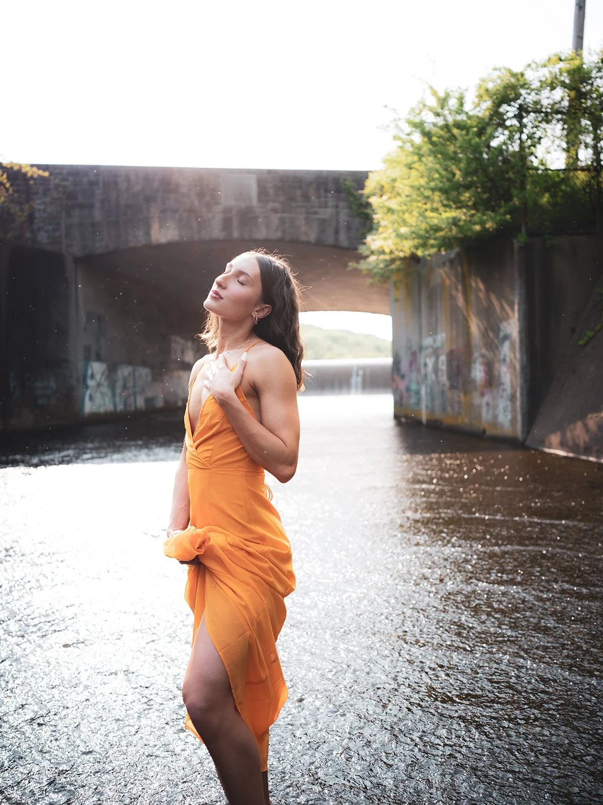 Portrait in an orange dress beneath the bridge