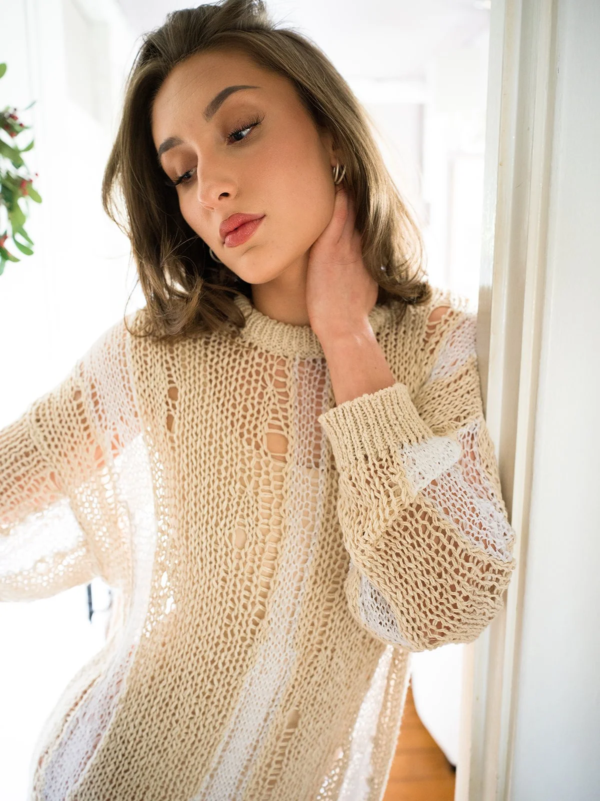 Close portrait in a cream open-knit sweater