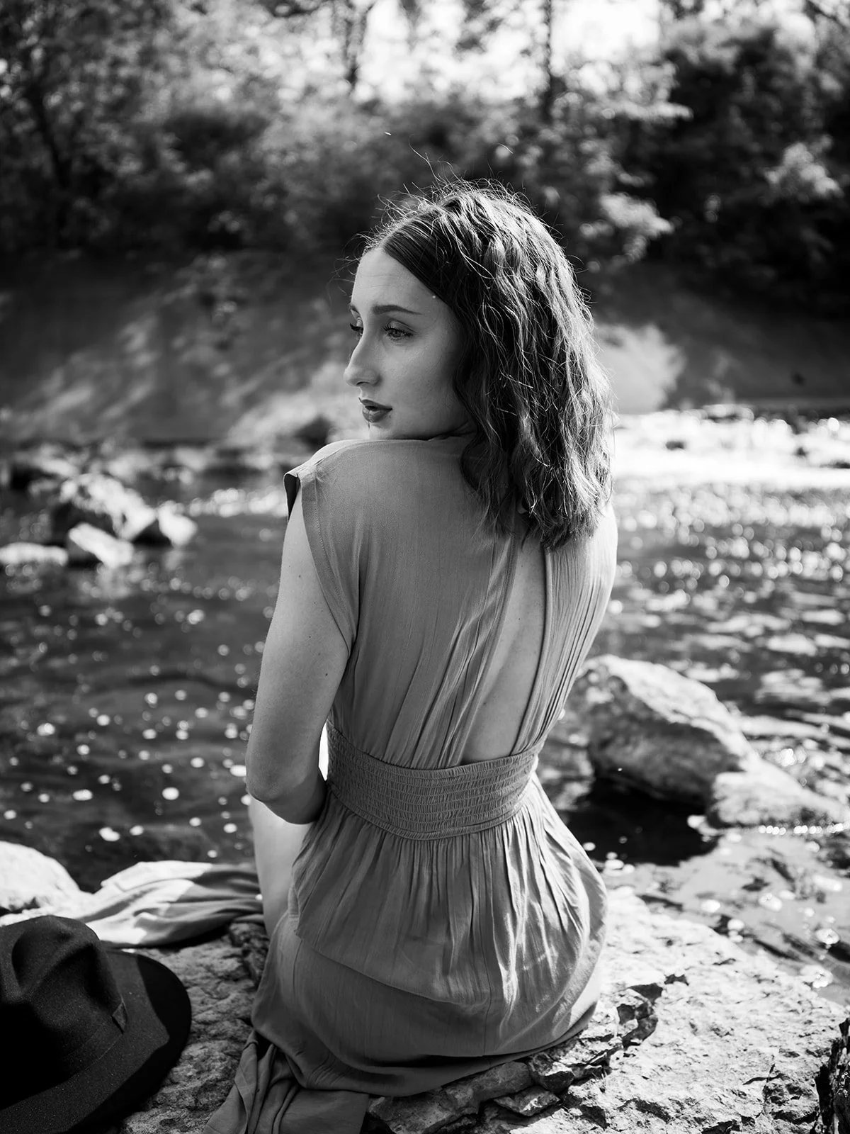 Black and white seated portrait beside the river