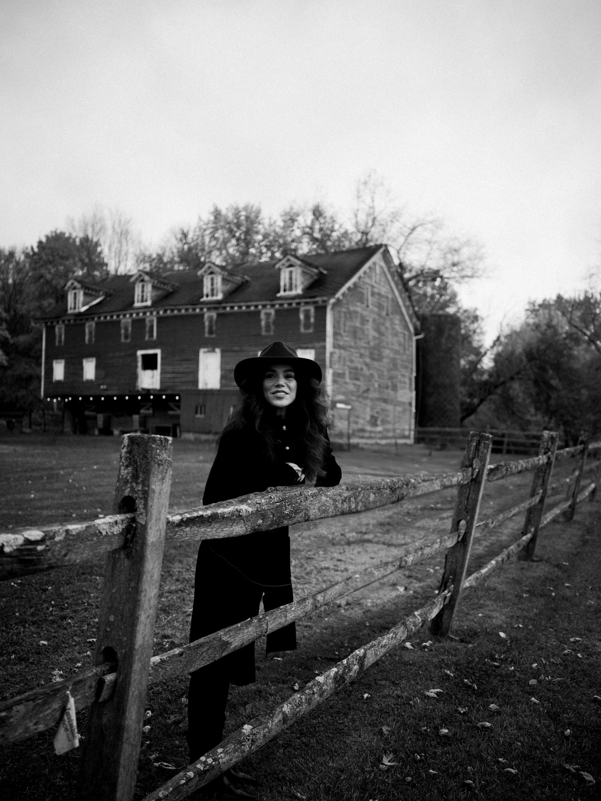 Cowgirl portrait beside a weathered fence