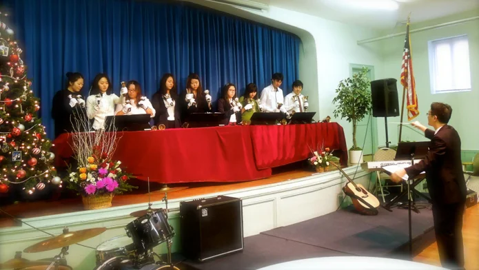 Handbell Surprise! Sunday 23 December 2012 Michael Kim of Evergreen Church of New York surprised us at QHCC by conducting an impromptu performance with their new handbell choir! We had just spent a half hour singing carols during our fellowship hour, when all of a sudden we were presented with flowers and then a magical rendition of Carol of the Bells . We extend our heartfelt thanks to Evergreen - who have been leasing out our facilities for years - for their kindness and generosity. It was a wonderful way to celebrate the Christmas season together! 
