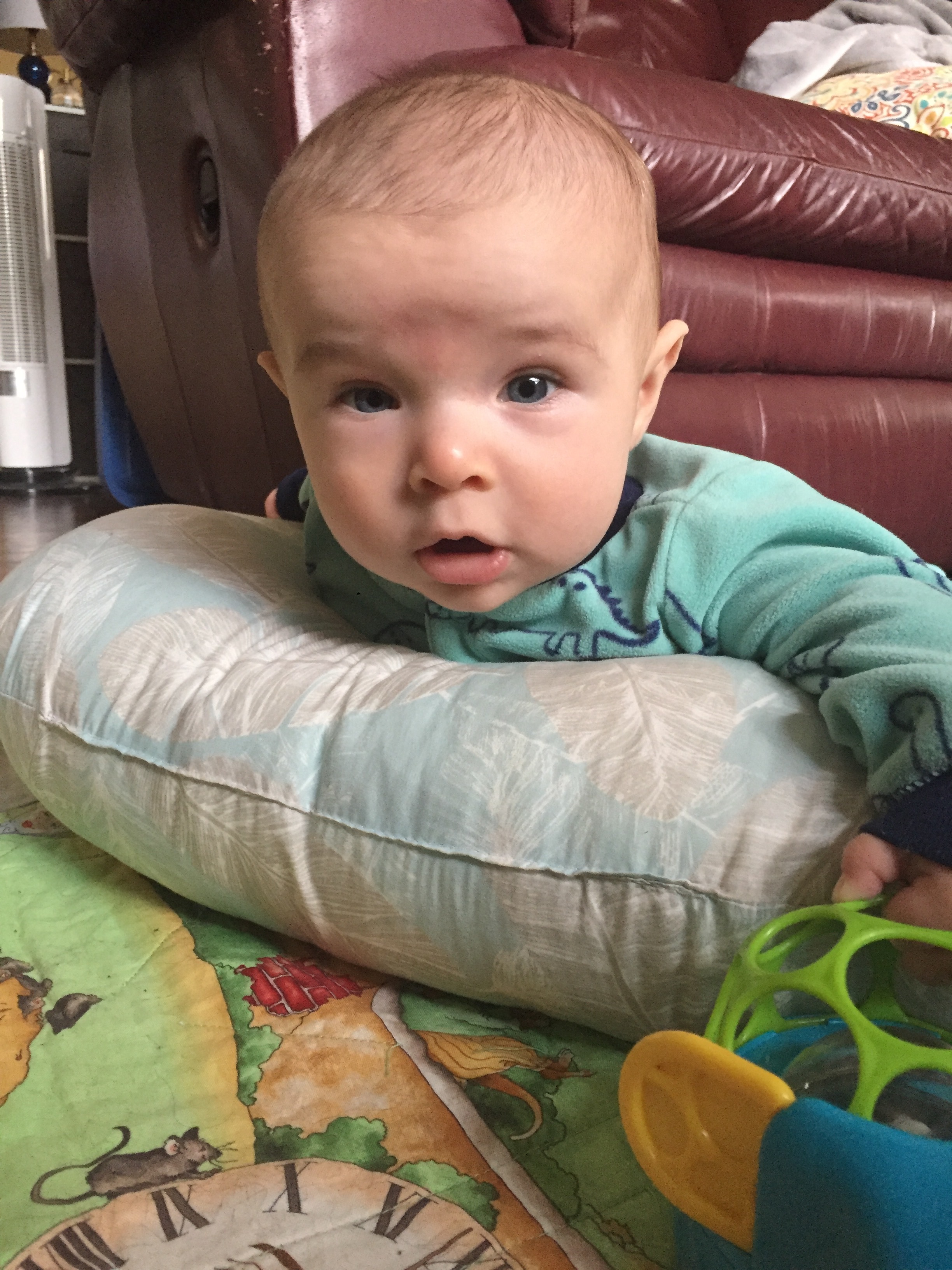  Tummy time is getting a bit better, thanks to a little boost! 