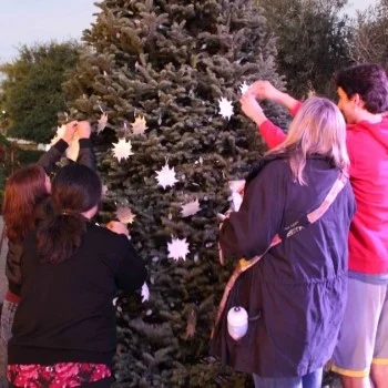 Community members affix stars to the Light Up A Life tree at Camino Real Marketplace in Goleta. (Hospice of Santa Barbara photo)