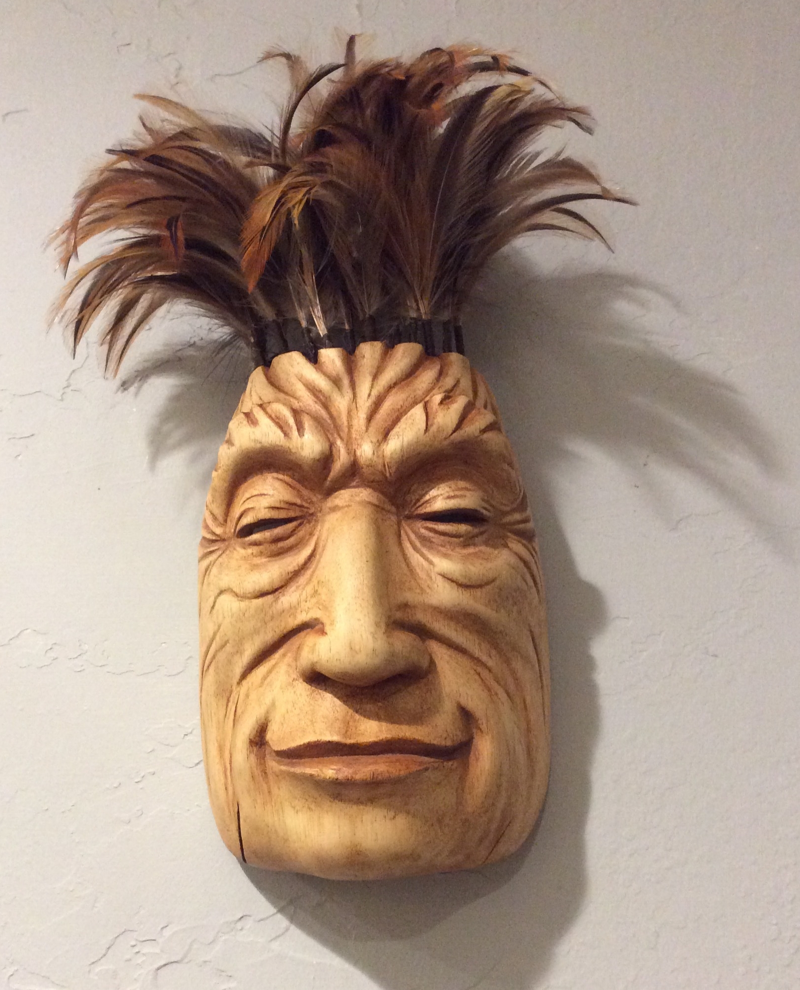 My mask from the second workshop was more playful. I didn't have an image in mind when I was carving but was trying for a peaceful smile. I had lots of fun making the feather duster hair. I actually took apart and reassembled a duster that I had been keeping for the feathers. 