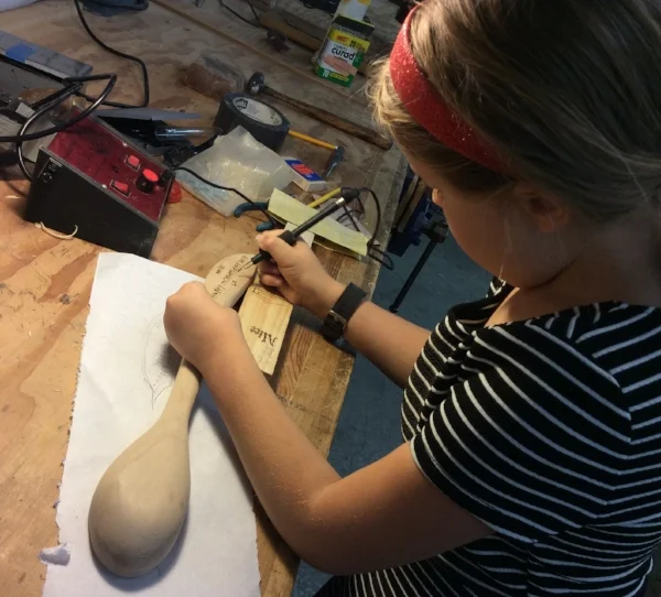 A trip down Memory Lane: Echo wood-burning the final touches on her spoon that she carved for her mother about two years ago. 